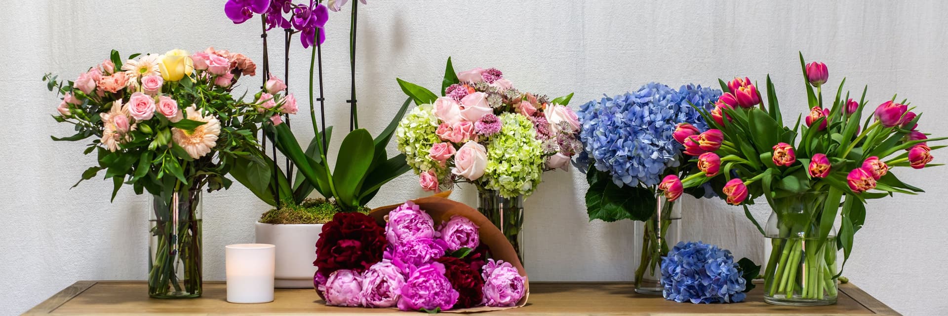 Elegant floral arrangement featuring peonies, roses, and hydrangeas in vibrant colors.