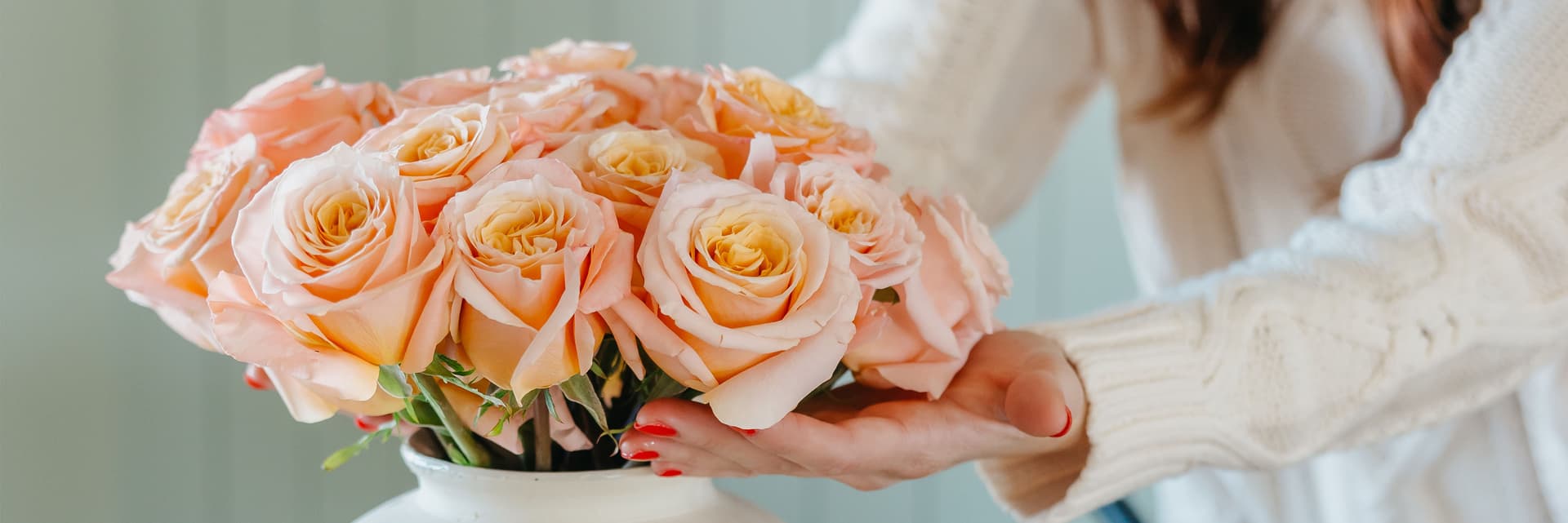 Soft peach roses arranged elegantly in a white vase, perfect for any occasion.